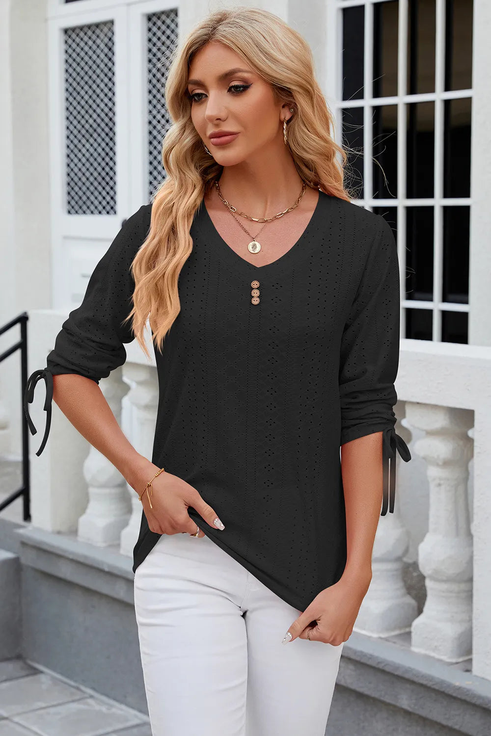 Black half sleeve blouse featuring eyelet embroidery and adjustable drawstring neckline