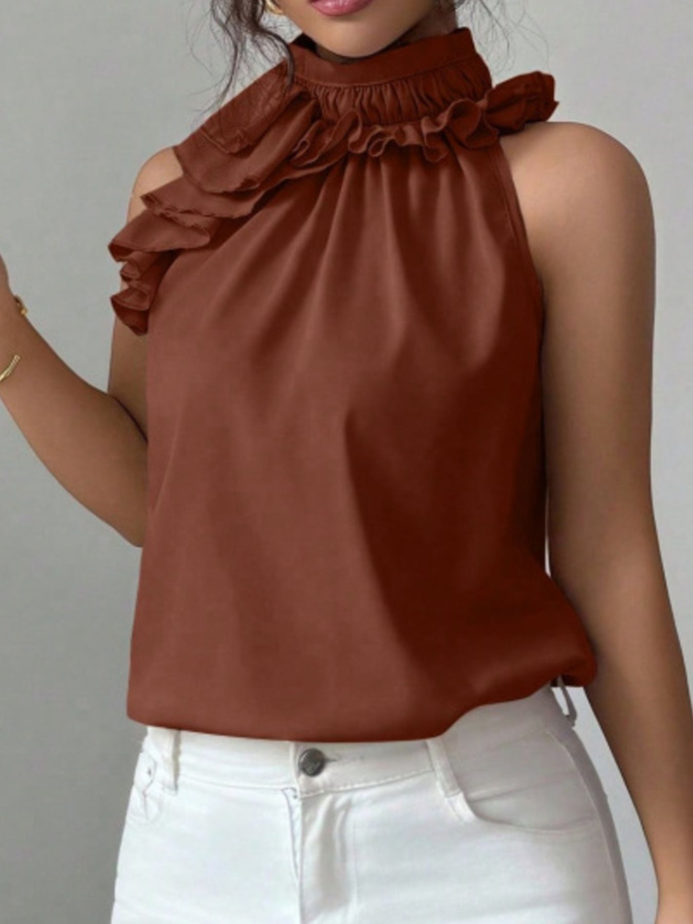 Detailed view of brown ruffle collar and buttoned neckline on sleeveless women's blouse
