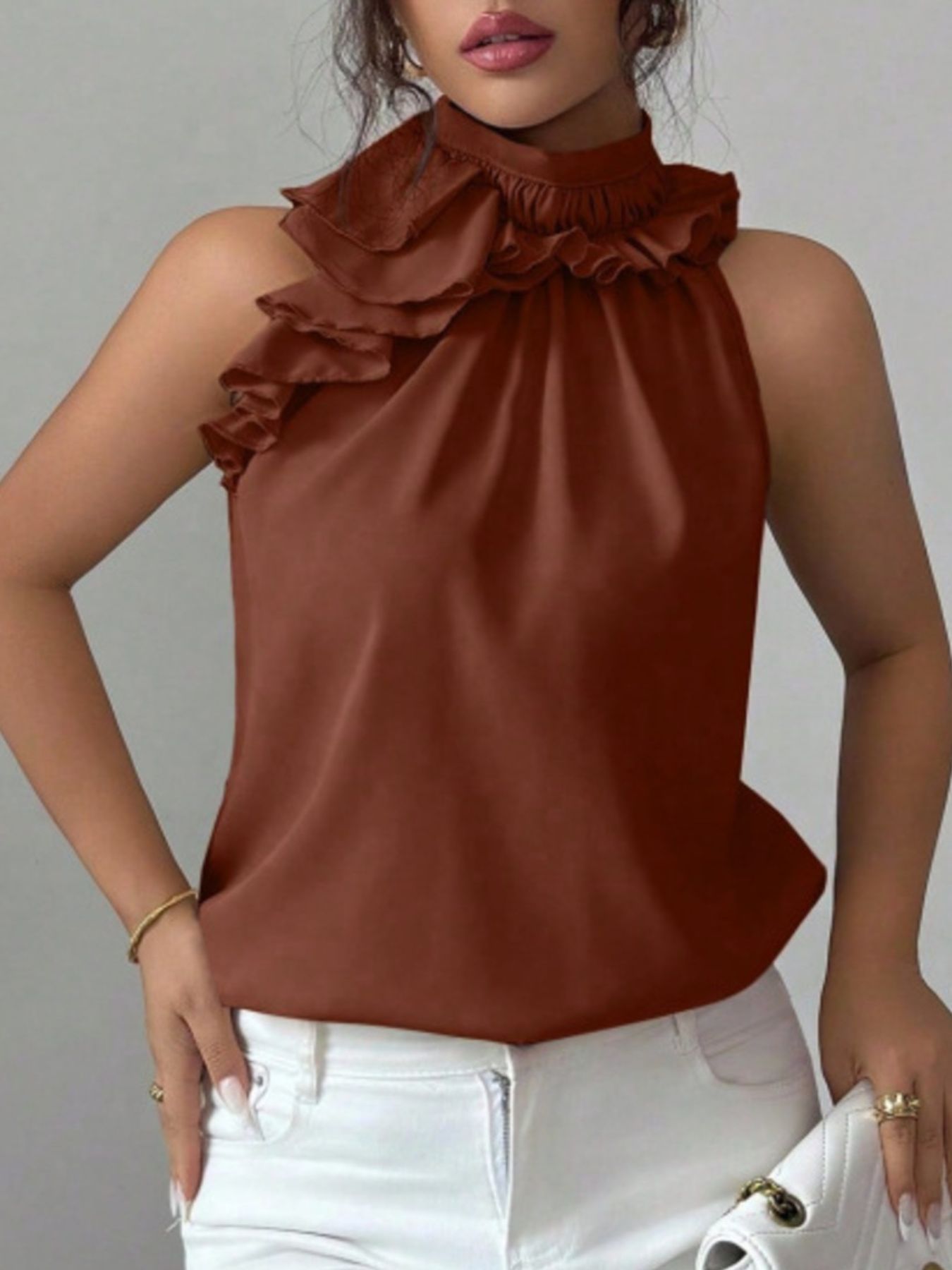 Brown sleeveless blouse with ruffle neckline and buttoned front shown from side angle