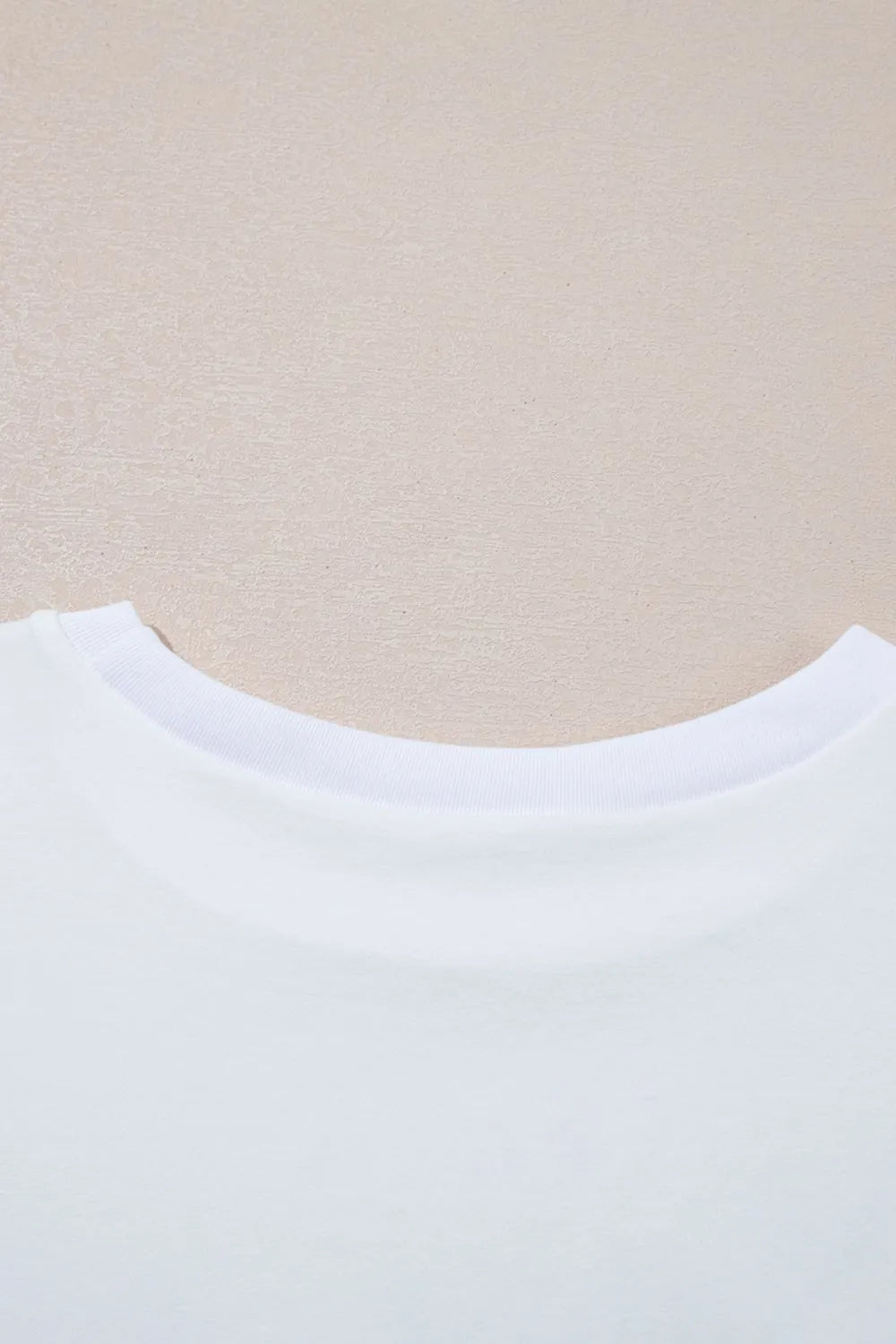 Close-up of a white shirt collar on a beige background