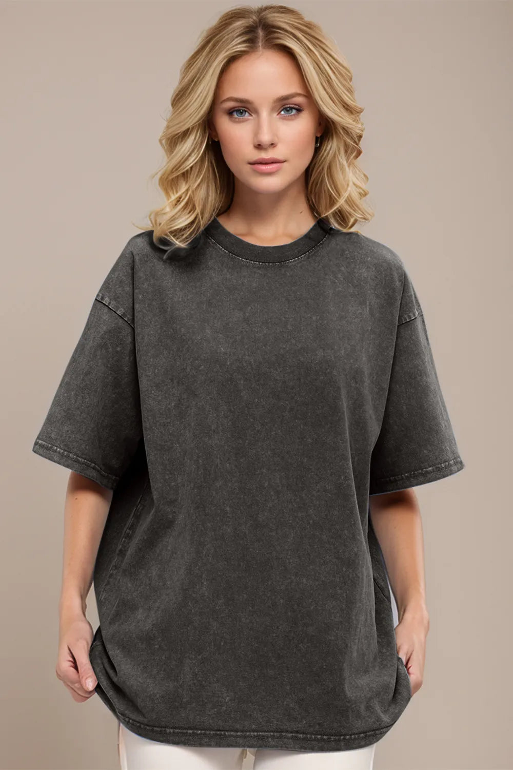 Woman wearing a dark gray oversized t-shirt against a beige background