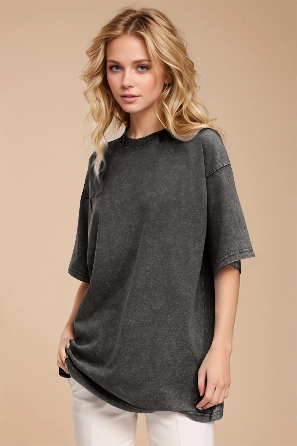 Woman wearing a dark gray oversized t-shirt against a beige background