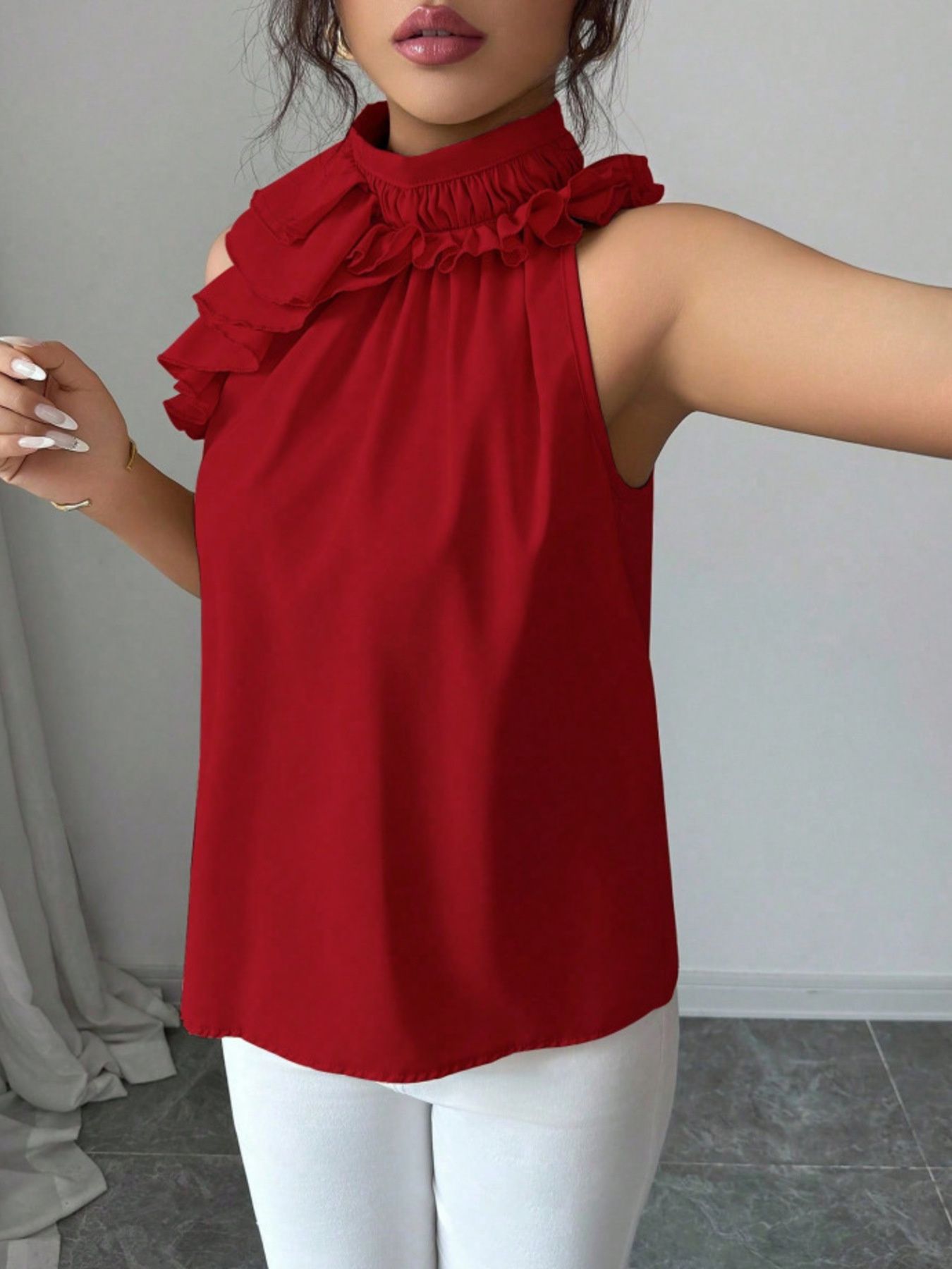Red sleeveless blouse featuring ruffle high neckline, button front design and lightweight summer fabric