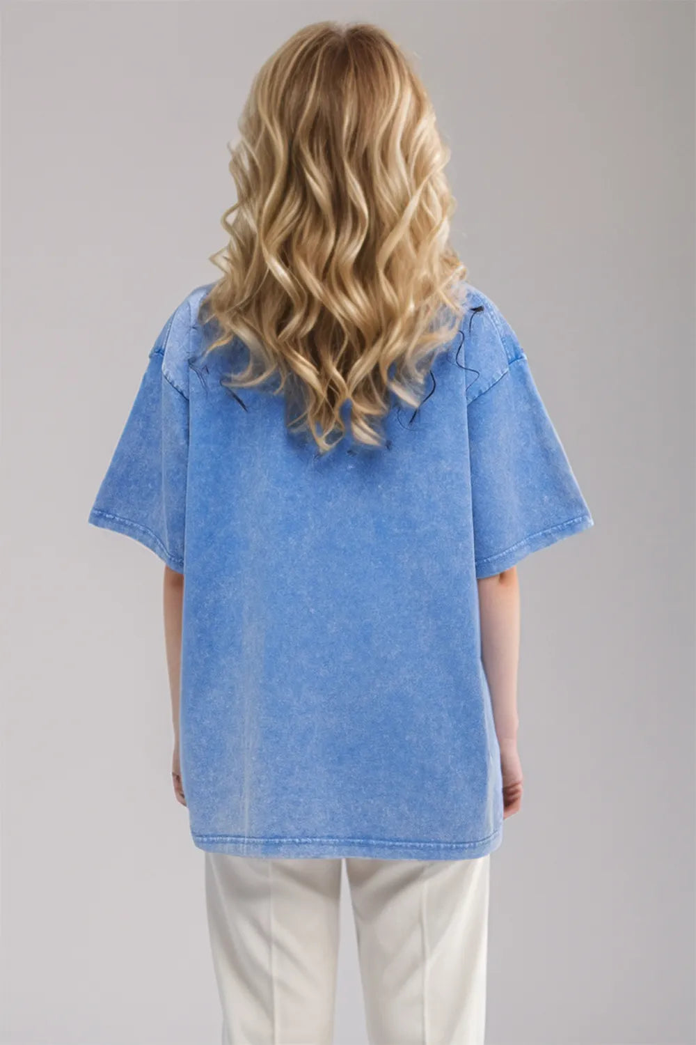 Person wearing a blue denim shirt with a plain background