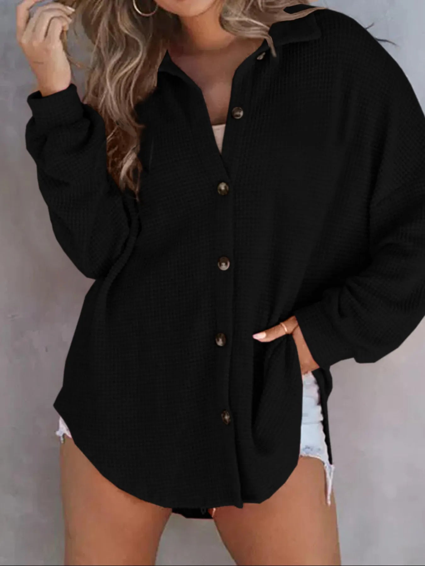 Black waffle knit button down shirt close up showcasing textured fabric chest pockets and buttons