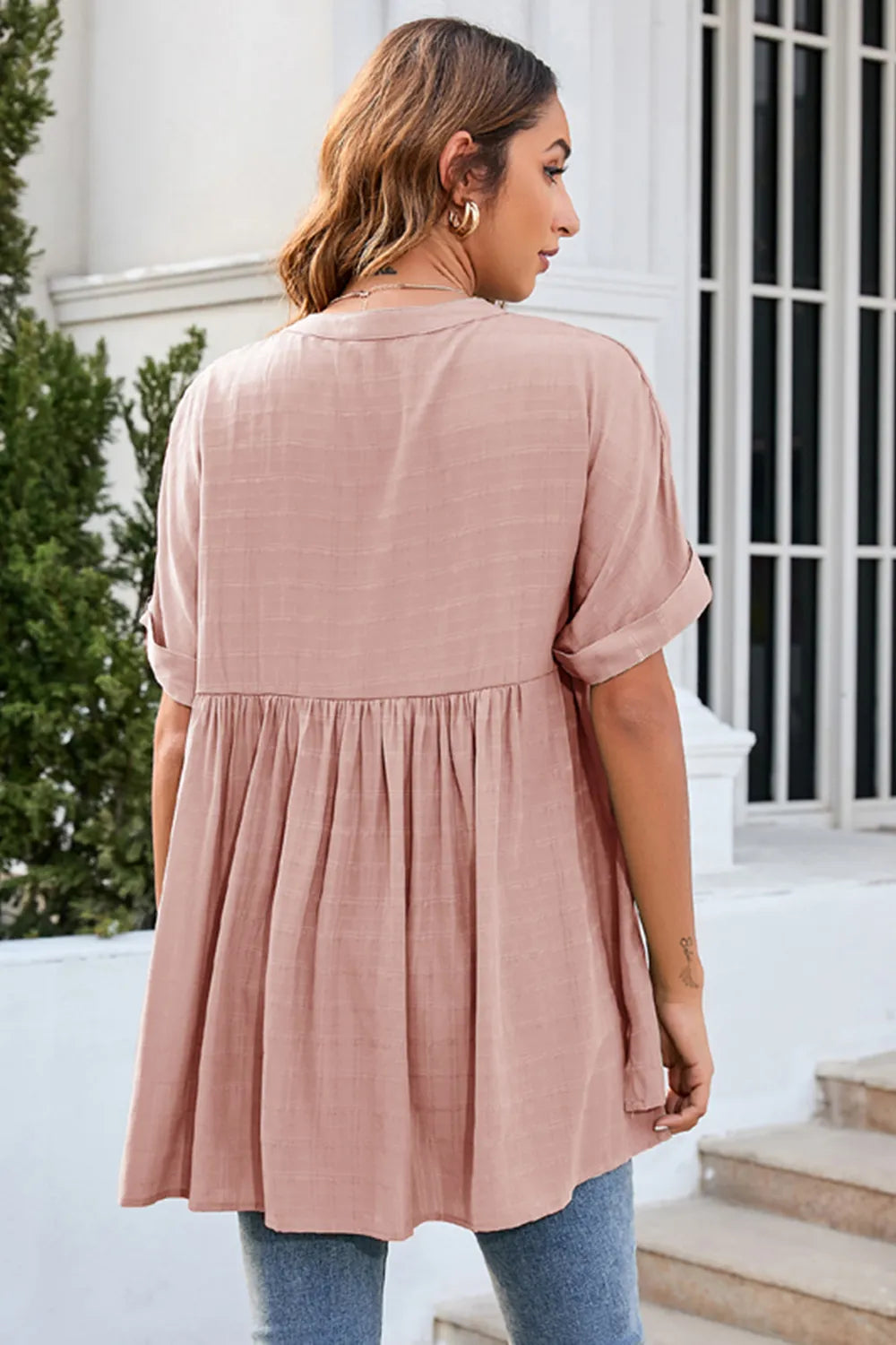 Back view of blush pink ruched short sleeve blouse with relaxed draped silhouette