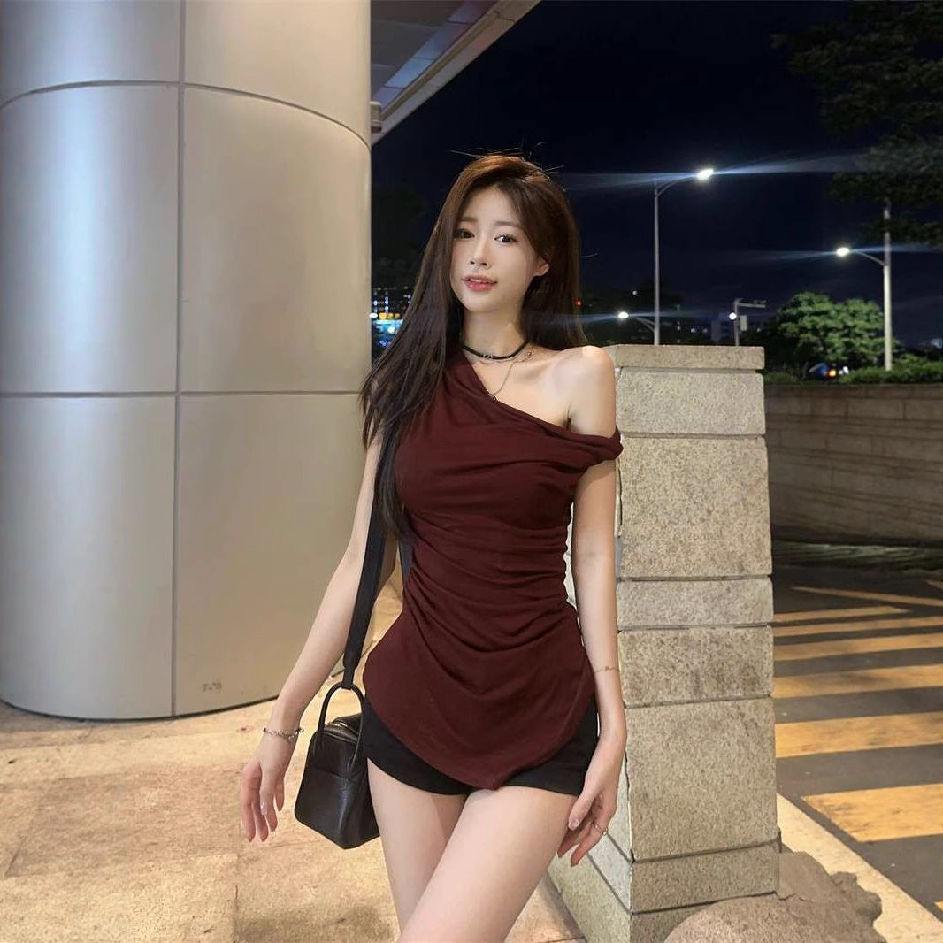 burgundy-pleated-one-shoulder-top-side
Side angle highlighting draped ruching and flattering waist-cinching effect on burgundy evening top


Woman in a burgundy top and black shorts standing outdoors at night.