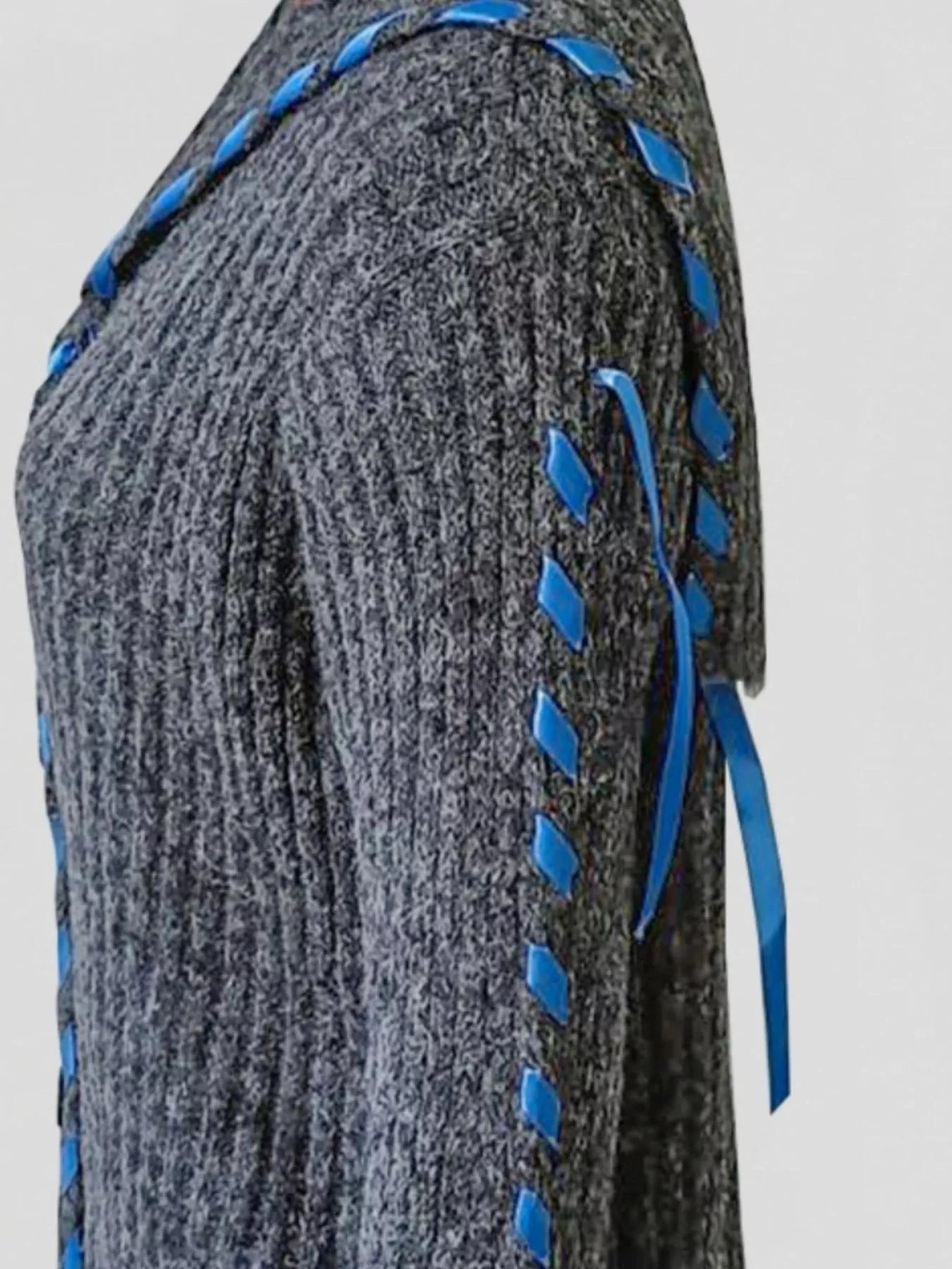 Cream cable knit cardigan featuring front buttons and contrast stitching, relaxed fit