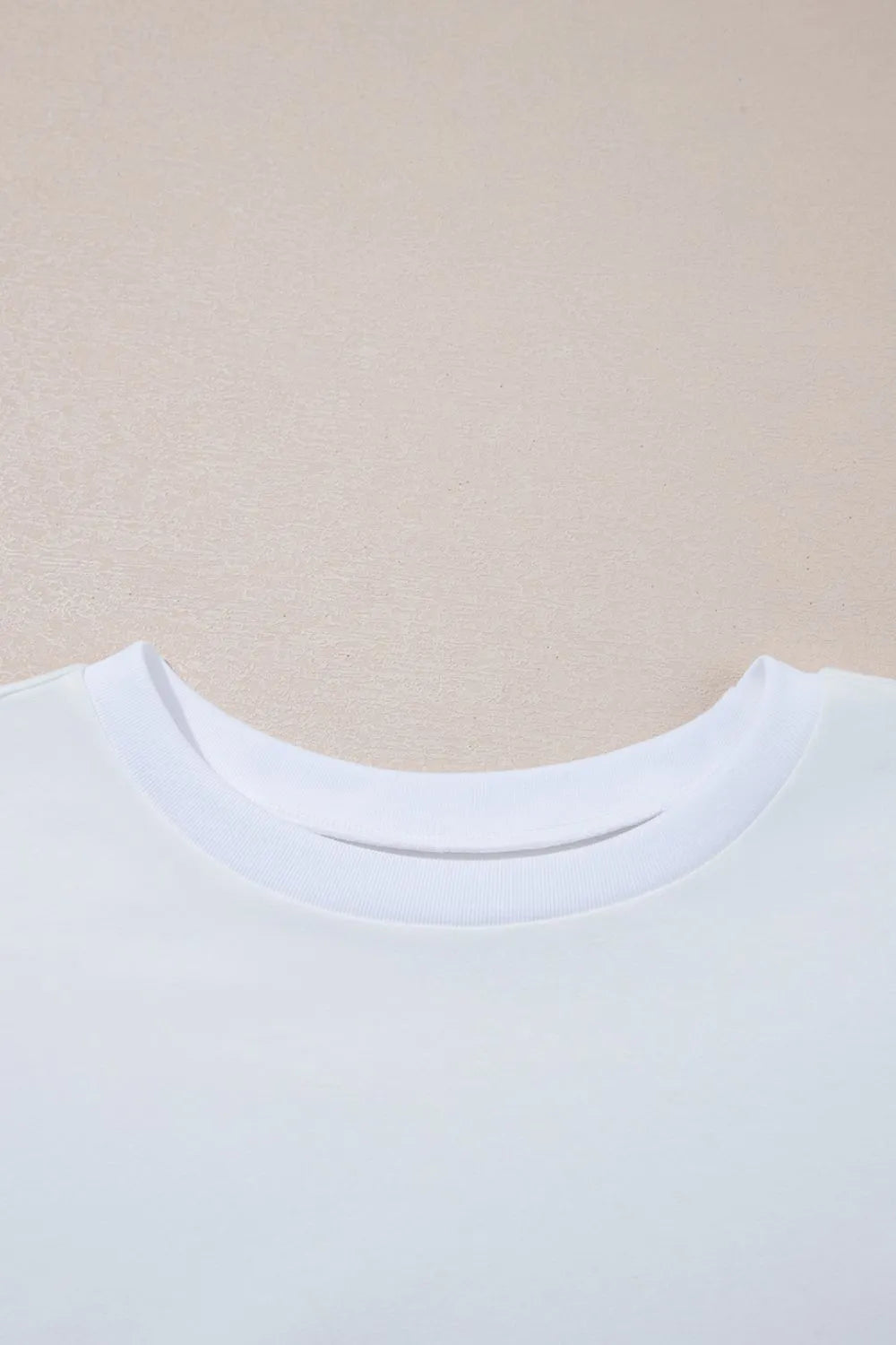 Close-up of a white shirt collar on a beige background