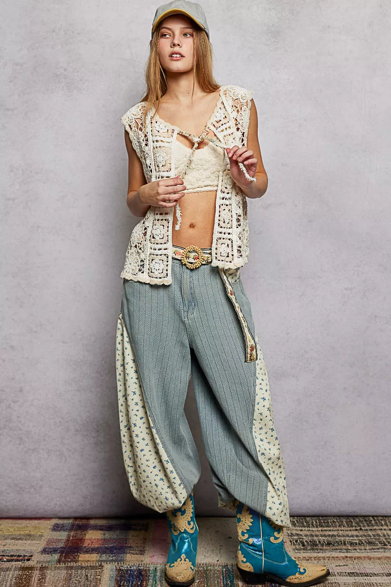 Flat lay of cream crochet sleeveless vest highlighting crochet patterns and drawstring