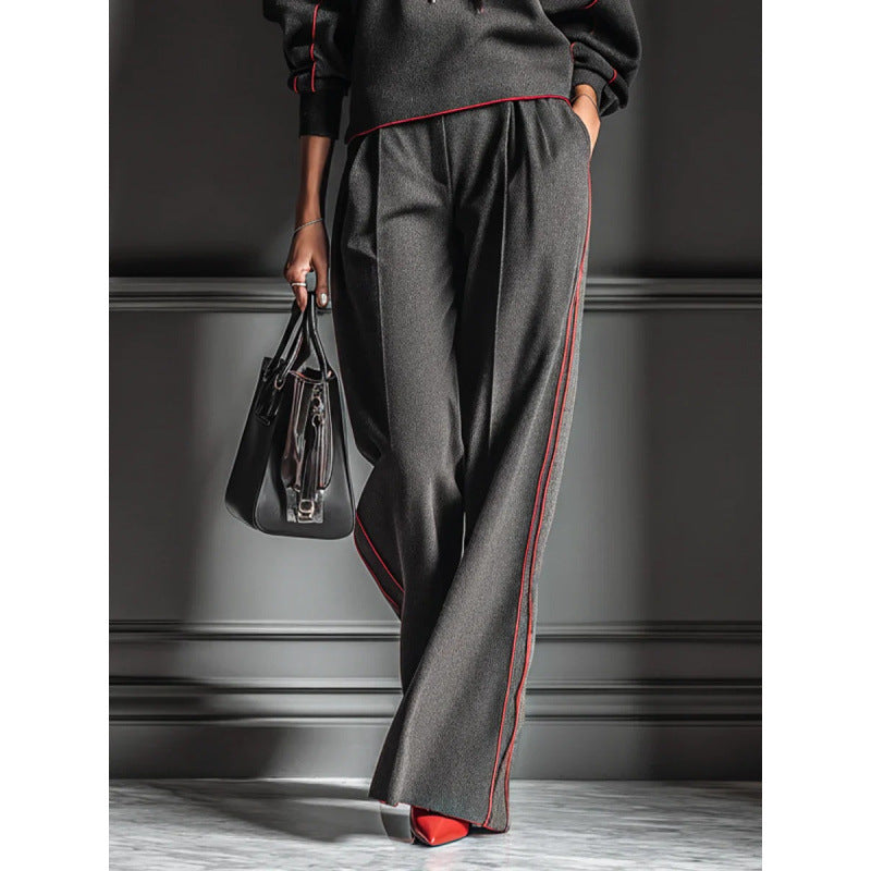 dark-grey-hoodie-set-travel-outfit
Travel-ready athleisure: dark grey color block tracksuit with crossbody bag and chunky sneakers

Person wearing a gray outfit with red accents, holding a black handbag against a dark background.