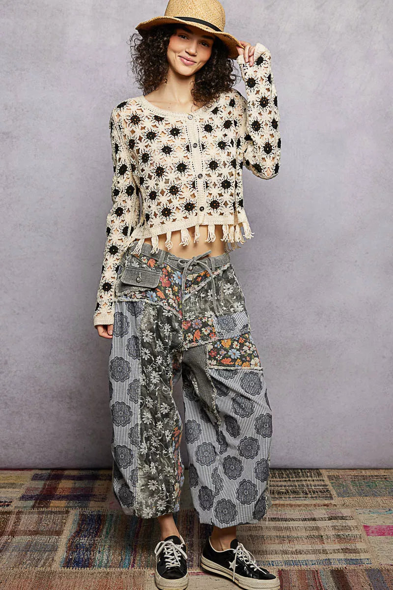 Woman wearing elegant cream crochet cardigan with floral pattern and tassel, perfect for casual sophistication