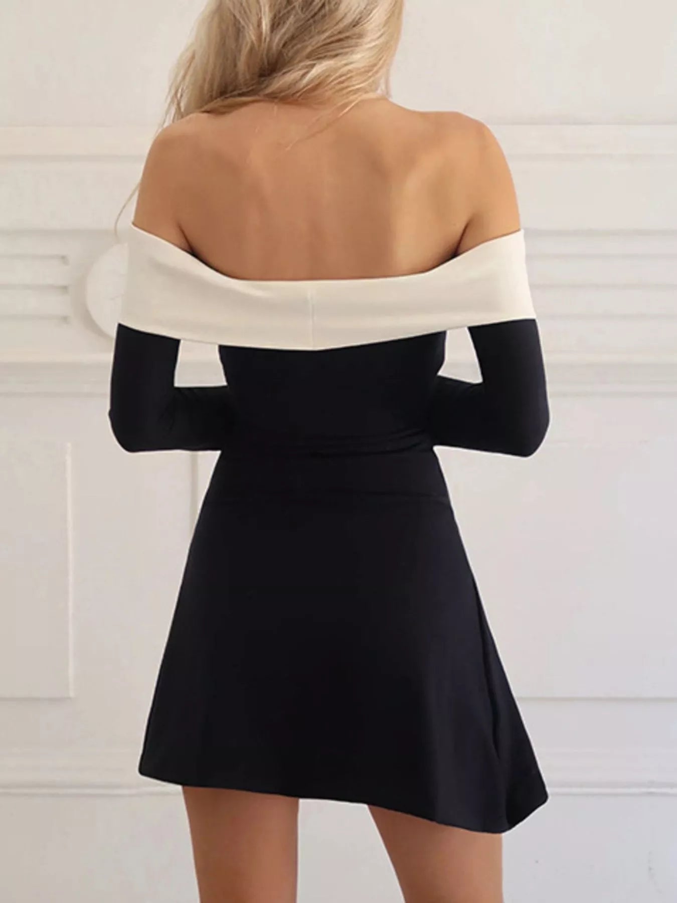 off-shoulder-black-dress-contrast-neckline-closeup
Close-up of striking white contrast trim on off-shoulder neckline and fitted bodice
Black and white dress with long sleeves on a plain background