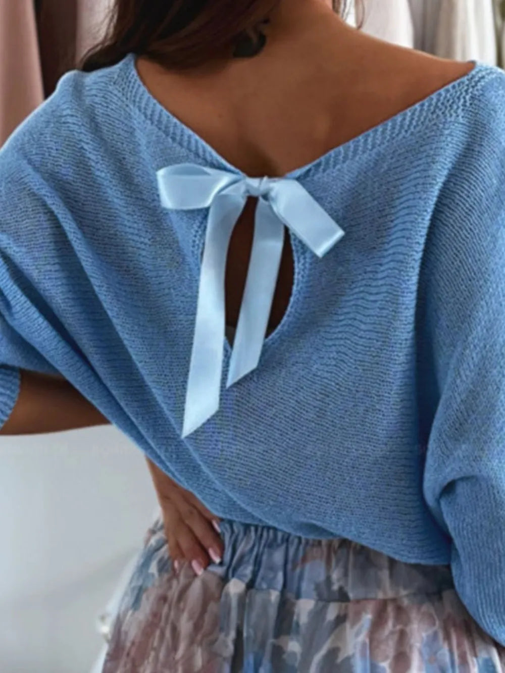 Long sleeve and off-shoulder drape detail on romantic bow back sweater

Blue sweater with a bow detail on a neutral background