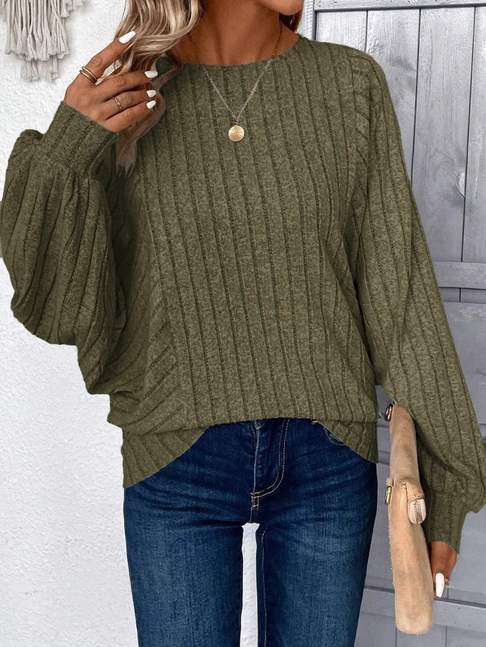 Person wearing a green sweater and blue jeans 