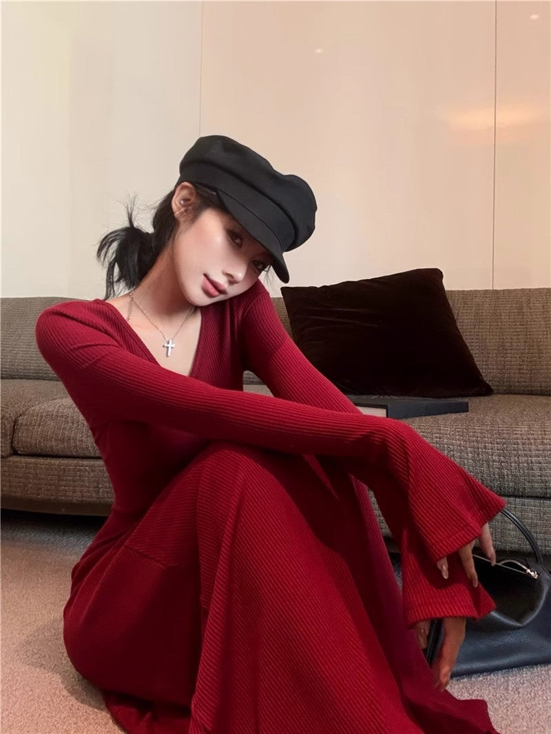red-a-line-maxi-side-movement
Side profile highlighting graceful flared hem movement and long flared sleeves on red ribbed maxi dress

Woman in a red dress and black cap sitting on a couch.