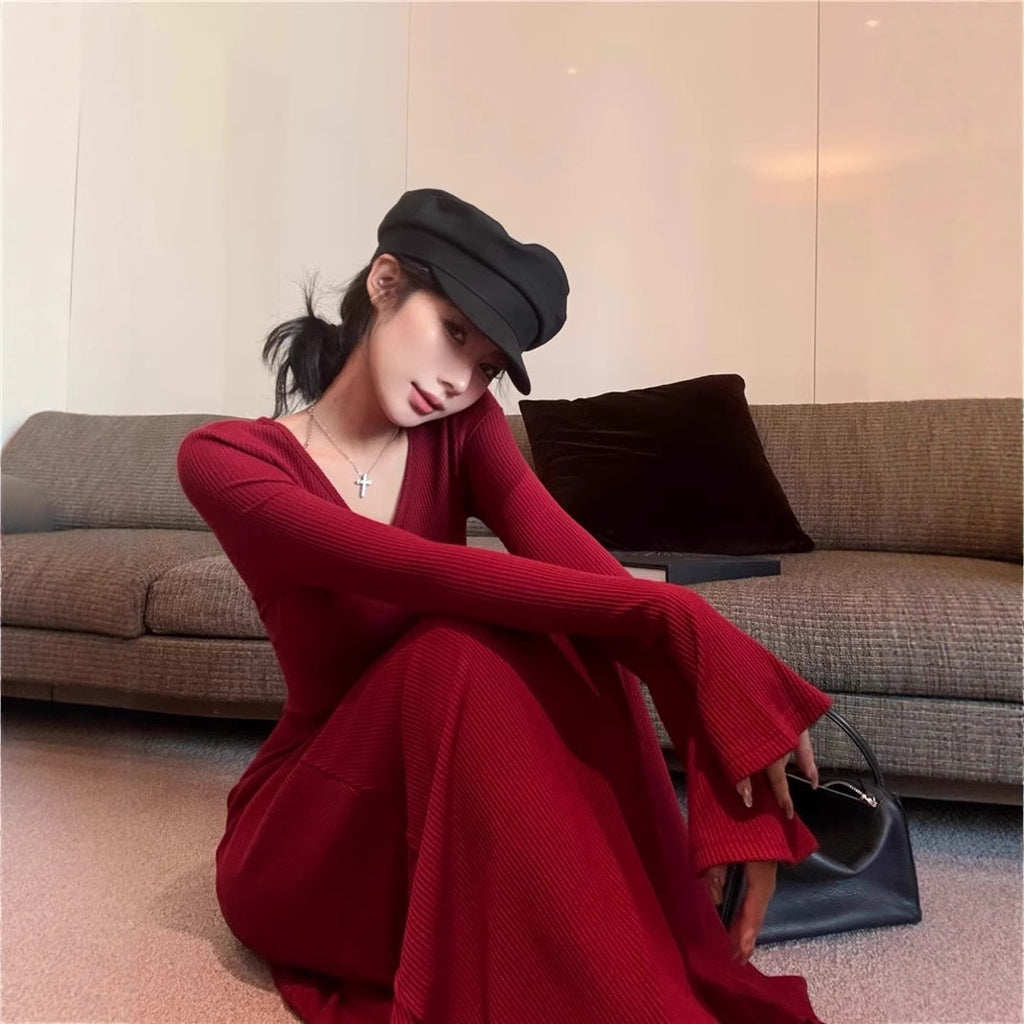 red-ribbed-maxi-dress-long-sleeve-front
Elegant red ribbed maxi dress with long flared sleeves and cinched waist, perfect evening or day-to-night look – OpusVenustas
Woman in a red dress and black hat sitting on a couch holding a handbag.