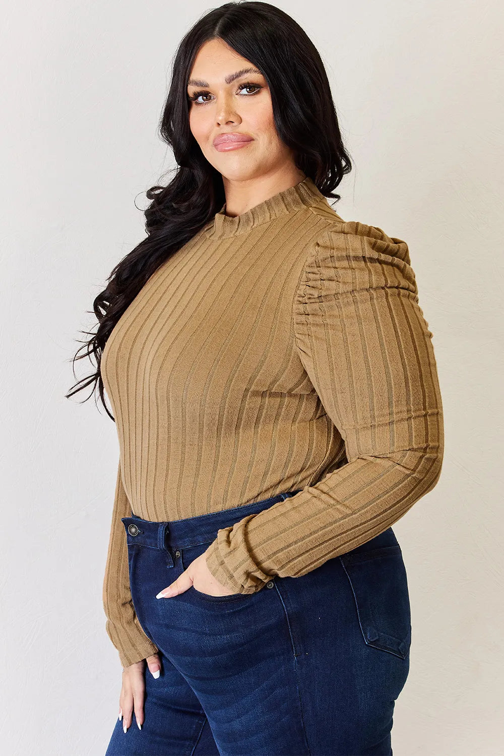 Woman wearing a brown ribbed long-sleeve top and blue jeans against a plain background. ribbed-stretch-top-fabric-swatch
Material close-up: 96% polyester 4% elastane soft ribbed knit