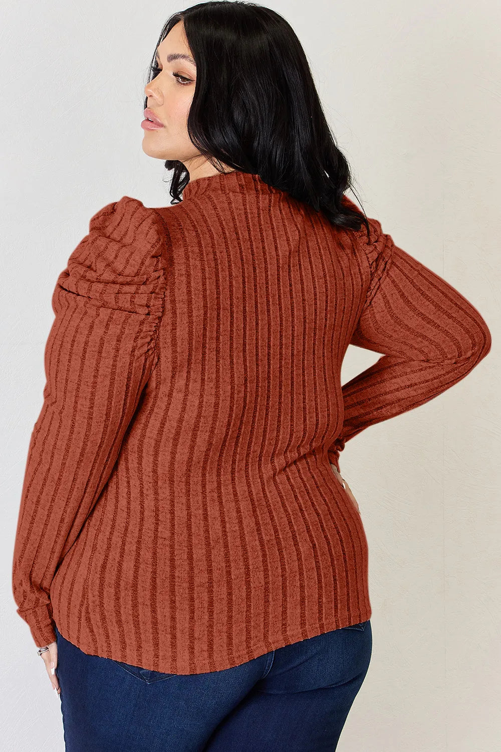 Detailed shot of ruched shoulder accent on elegant ribbed knit blouse