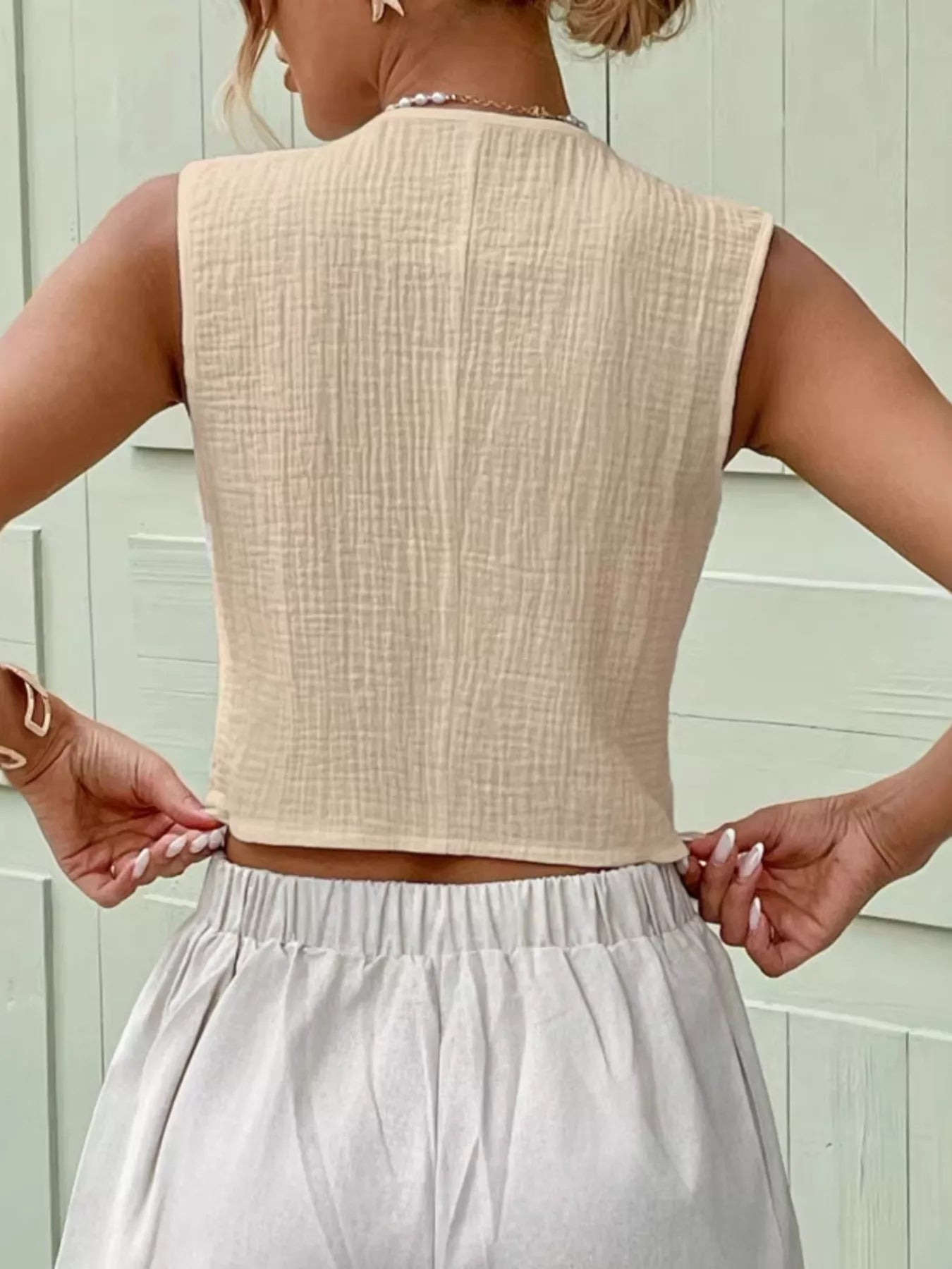 Back view of an apricot textured cotton vest top with a clean sleeveless silhouette