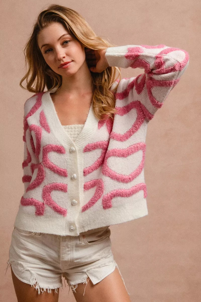 Side view showing relaxed fit and ribbed hem of heart button cardigan